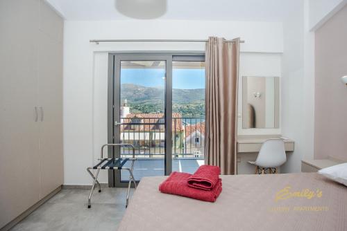 Un dormitorio con una cama con una toalla roja. en Emily's Luxury Apartments en Argostoli