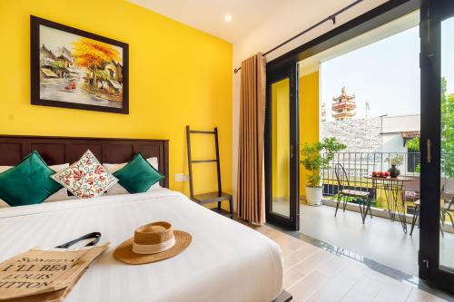 a bedroom with a bed with a hat on it at Villa Ohana Gadren by Cocoviet Hoi An in Hoi An