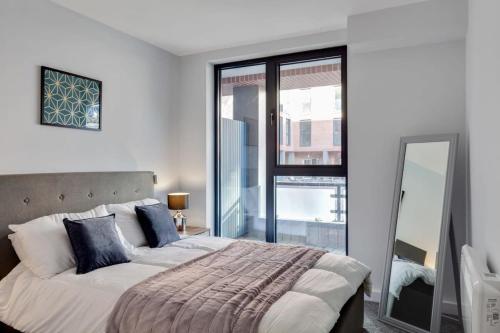 1 dormitorio con cama grande y ventana grande en Modern Fabulous Flat In Central Birmingham en Birmingham