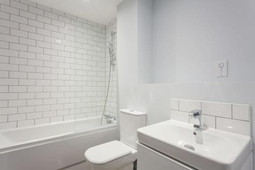 Baño blanco con aseo y lavamanos en Modern Fabulous Flat In Central Birmingham en Birmingham