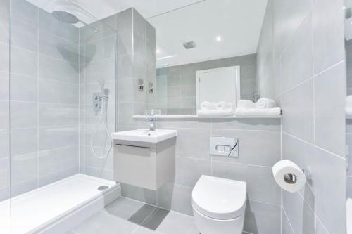 a white bathroom with a toilet and a sink at Modern and Bright 2 Bed Apartment in Solihull in Birmingham