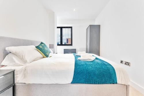 a bedroom with a large bed with a blue blanket at Modern and Stylish 2 Bed Apartment in Solihull in Birmingham