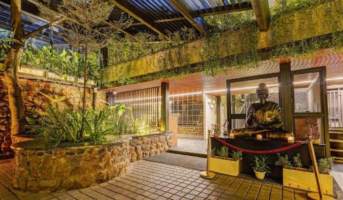hol z posągiem w budynku z roślinami w obiekcie Palette - The Slate Hotel w mieście Ćennaj