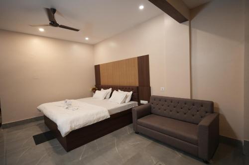 a bedroom with a bed and a couch at Hotel New Sagar Priya in Digha