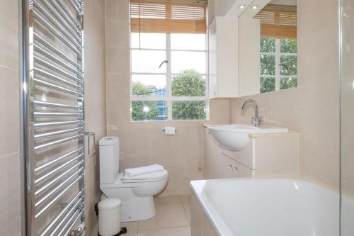 y baño con aseo, lavabo y bañera. en Bright & Spacious Top Floor Apartment in Chelsea, en Londres