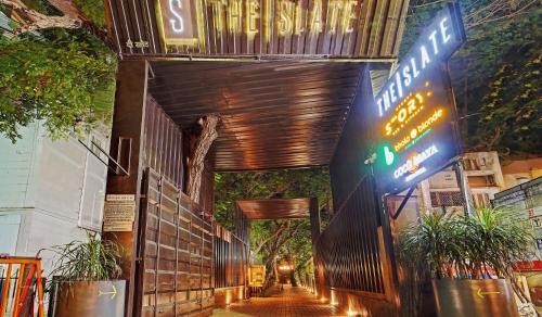 una pasarela que conduce a un edificio con una señal en Palette - The Slate Hotel, en Chennai