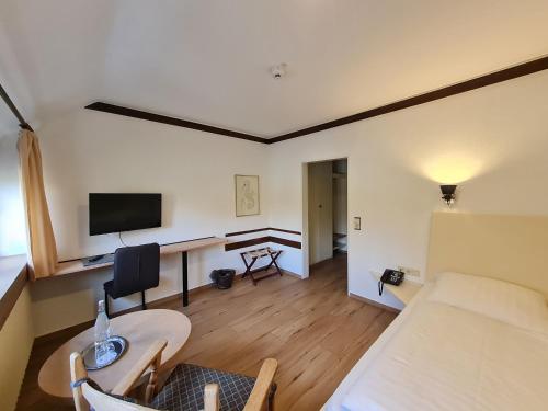 a living room with a couch and a desk with a television at Hof Hueck in Bad Sassendorf