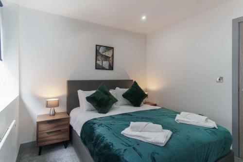 a bedroom with a bed with green sheets and pillows at Fantastic 1 Bedroom Apartment in Preston in Preston