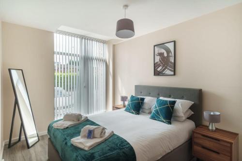 um quarto com uma cama com almofadas azuis e uma janela em Bright & Modern 1 Bed Apartment in Manchester em Manchester