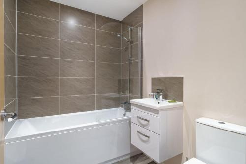 uma casa de banho com uma banheira branca e um lavatório. em Bright & Modern 1 Bed Apartment in Manchester em Manchester