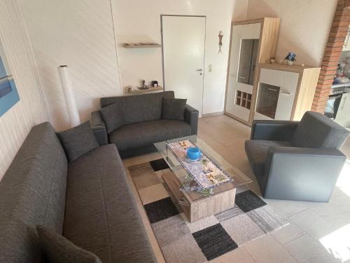 een woonkamer met 2 banken en een salontafel bij Ferienhaus Gomann in Dornum