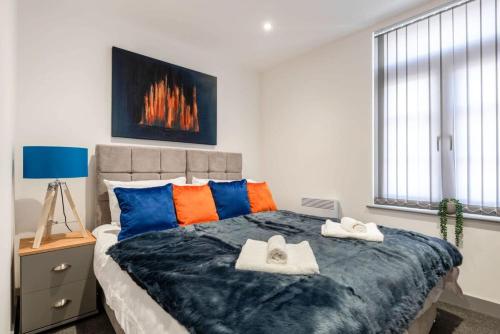 ドンカスターにあるModern Budget Apartment in Central Doncasterのベッドルーム1室(大型ベッド1台、カラフルな枕付)