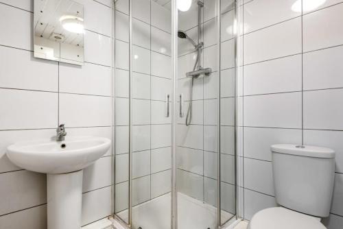 a bathroom with a shower and a toilet and a sink at Bright 1 Bedroom Budget Flat in Central Pontefract in Pontefract
