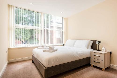 a bedroom with a bed and a large window at Bright 1 Bedroom Budget Flat in Central Pontefract in Pontefract