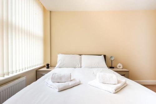 a bedroom with a white bed with two towels on it at Bright 1 Bedroom Budget Flat in Central Pontefract in Pontefract