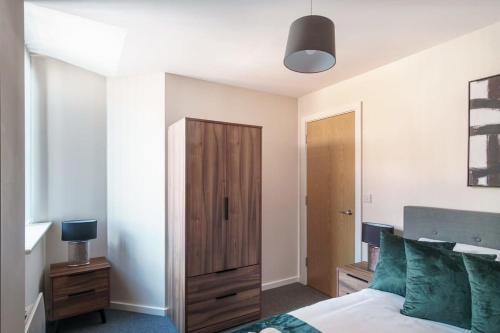 um quarto com uma cama e um armário de madeira em Contemporary 1 Bed Manchester Apartment em Manchester