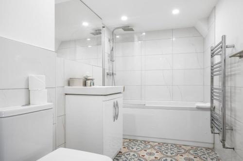 La salle de bains blanche est pourvue d'une douche et de toilettes. dans l'établissement Modern 2 Bedroom Apartment in Central Woking, à Woking