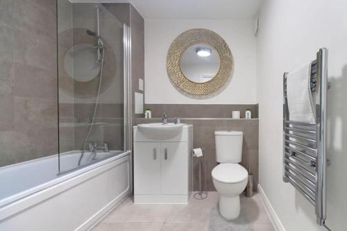 a bathroom with a toilet and a bath tub and a mirror at Modern 1 Bedroom Apartment in Central Ashford in Ashford