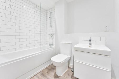 a white bathroom with a toilet and a sink at Central Birmingham 1 Bedroom Apartment in Birmingham
