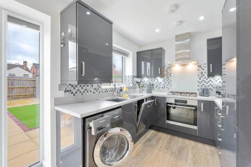 a kitchen with a washing machine in the middle at Modern 1 Bedroom House in Burton-on-Trent in Burton upon Trent