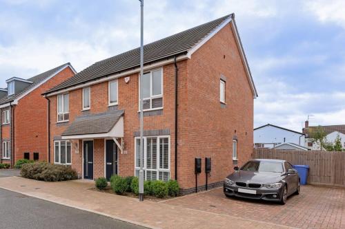 a brick house with a car parked in front of it at Modern 1 Bedroom House in Burton-on-Trent in Burton upon Trent