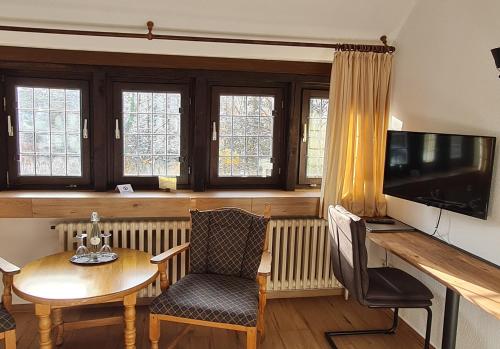 a living room with a table and a television at Hof Hueck in Bad Sassendorf