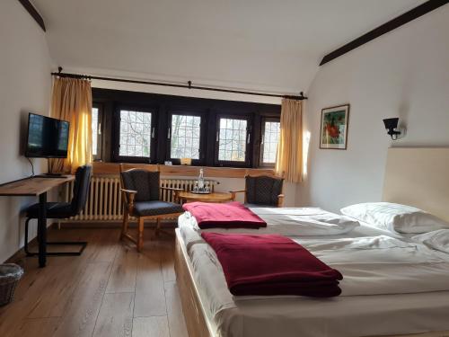 a bedroom with a bed and a desk with a computer at Hotel Restaurant Hof Hueck in Bad Sassendorf