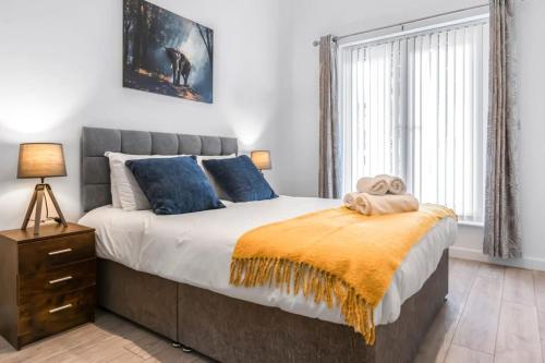 een slaapkamer met een groot bed met blauwe kussens bij Lovely 1 Bedroom Apartment in Central Woking in Woking