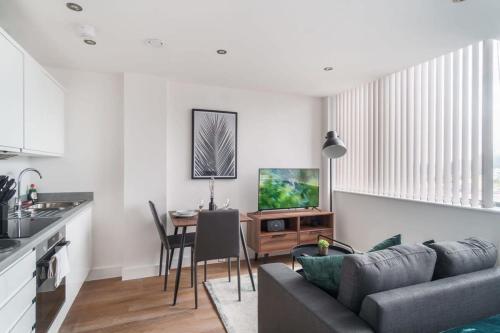 a living room with a couch and a table at Stay Zeni, Alexandra Rise Manchester Cosy Studio in Manchester