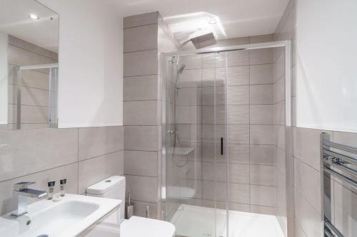 a bathroom with a shower and a toilet and a sink at Stay Zeni, Alexandra Rise Manchester Cosy Studio in Manchester
