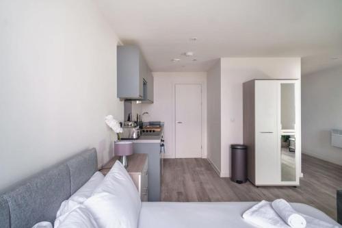 a living room with a bed and a kitchen at Spacious Studio in Central Liverpool in Liverpool
