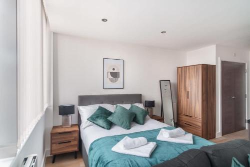 a bedroom with a bed with two towels on it at Stay Zeni, Alexandra Rise Manchester Cosy Studio in Manchester
