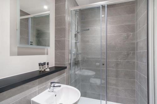 a bathroom with a shower with a sink and a toilet at Spacious Studio in Central Liverpool in Liverpool