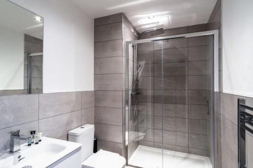 a bathroom with a shower and a toilet and a sink at Bright & Modern 1 Bed Apartment by Old Trafford in Manchester