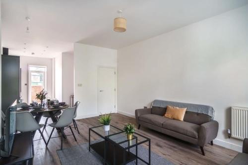 a living room with a couch and a table at Spacious 3 Bed Apartment in Waterloo Liverpool in Waterloo