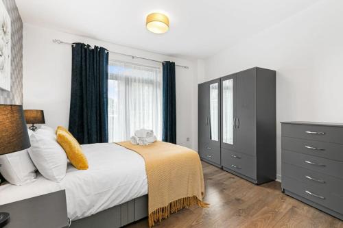 ein Schlafzimmer mit einem Bett, einer Kommode und einem Fenster in der Unterkunft Spacious 1 Bedroom Apartment in Central Woking in Woking