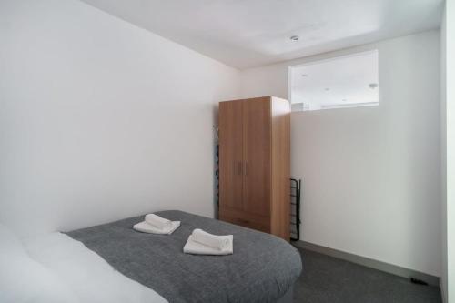 Cosy 1 Bed Apartment in Central Blackburn في بلاكبيرن: غرفة نوم بسرير وخزانة خشبية