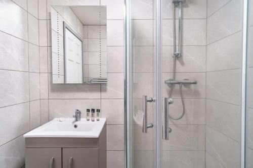bagno bianco con doccia e lavandino di Cosy 1 Bed Apartment in Central Blackburn a Blackburn