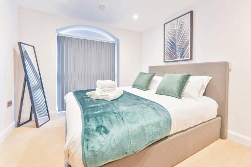 a bedroom with a large bed with green and white pillows at Spacious 1 Bed Apartment in Burton-on-Trent in Burton upon Trent