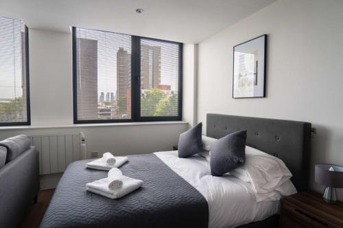 a bedroom with a bed with two towels on it at Cosy Studio Apartment by Old Trafford in Manchester