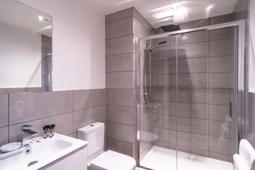 een badkamer met een douche, een toilet en een wastafel bij Charming 1 Bed Apartment in Old Trafford in Manchester