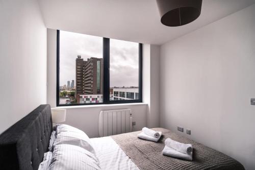 a bedroom with a bed with two towels on it at Charming 1 Bed Apartment in Old Trafford in Manchester