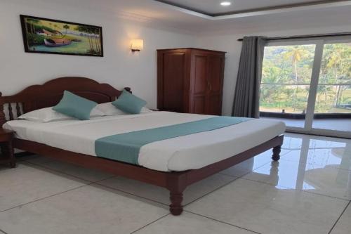 a bedroom with a large bed with a large window at Tattvam Wild Ocean in Arambol