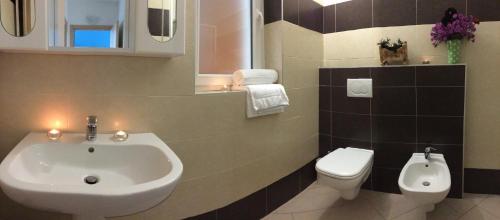 a bathroom with a sink and a toilet at Residence Le Azalee & SPA in Vercana