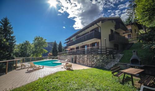 a villa with a swimming pool and a house at Residence Panorama in Molina di Ledro