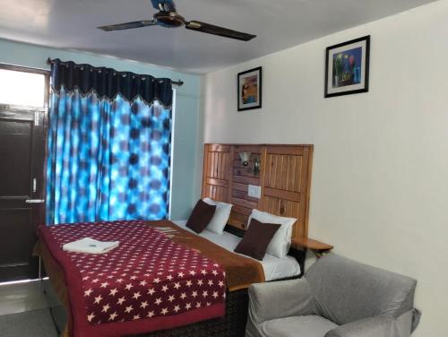 1 dormitorio con 1 cama, 1 silla y 1 ventana en Aman Inn, en Dharamshala
