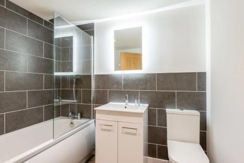 a bathroom with a toilet and a sink and a bath tub at Modern 2 Bedroom Apartment in Central Hull in Hull