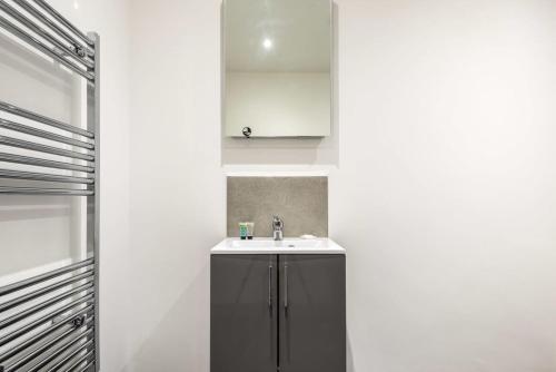 a bathroom with a sink and a mirror at Smart 1 Bedroom Apartment in Leeds in Leeds