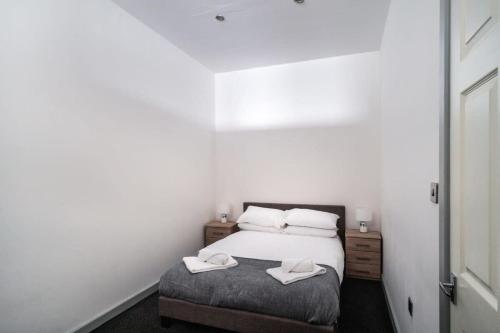 a bedroom with a bed with two towels on it at Lovely 1 Bed Apartment in Central Blackburn in Blackburn