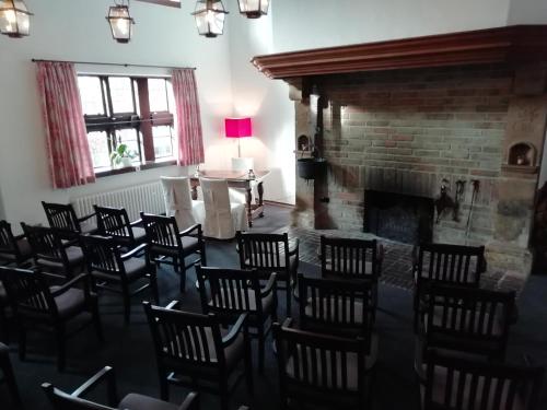 a room filled with chairs and a fireplace at Hof Hueck in Bad Sassendorf
